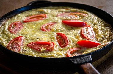 Dökme demir tavada patates ve domatesli Rustik omlet..