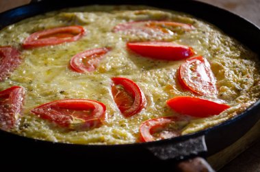 Dökme demir tavada patates ve domatesli Rustik omlet..