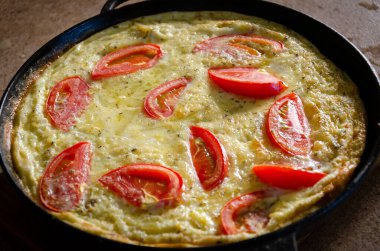 Dökme demir tavada patates ve domatesli Rustik omlet..