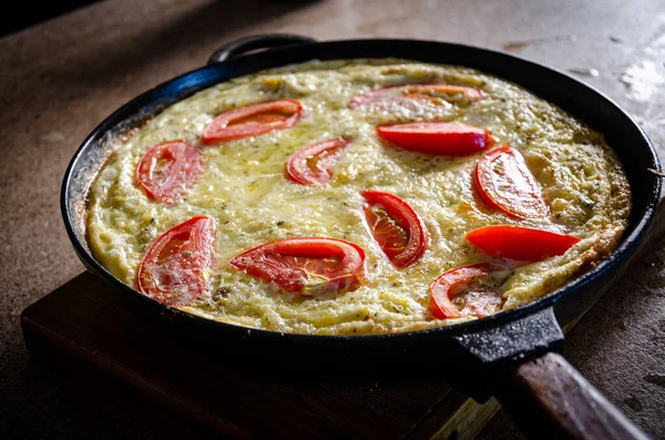 Dökme demir tavada patates ve domatesli Rustik omlet..