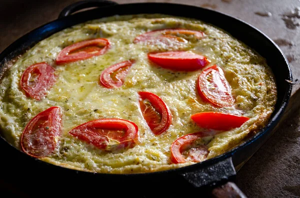 Dökme demir tavada patates ve domatesli Rustik omlet..