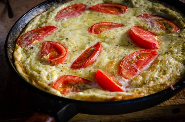 Dökme demir tavada patates ve domatesli Rustik omlet..