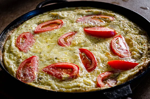 Dökme demir tavada patates ve domatesli Rustik omlet..