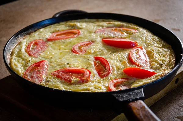 Dökme demir tavada patates ve domatesli Rustik omlet..