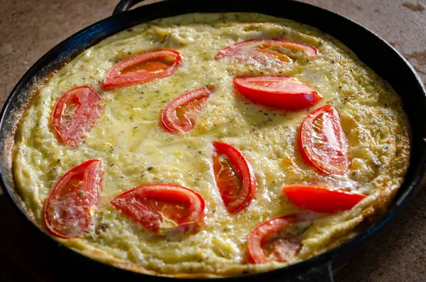 Dökme demir tavada patates ve domatesli Rustik omlet..