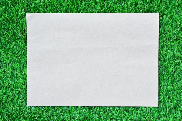 Brown paper on green grass — Stock Photo, Image