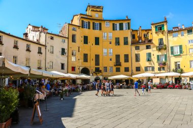 Lucca, İtalya - Eylül 2018. Turistler Lucca 'daki ünlü Piazza dell' Anfiteatro meydanını ziyaret ettiler.