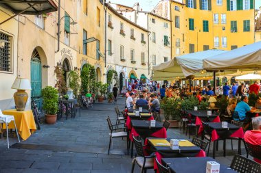 Lucca, Italy - Circa September 2018. Tourists visit famous square Piazza dell'Anfiteatro in Lucca. clipart