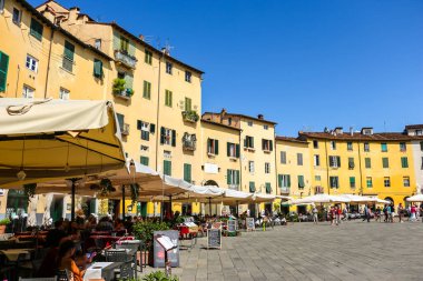 Lucca, İtalya - Eylül 2018. Turistler Lucca 'daki ünlü Piazza dell' Anfiteatro meydanını ziyaret ettiler.