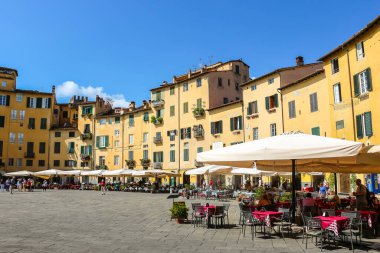 Lucca, İtalya - Eylül 2018. Turistler Lucca 'daki ünlü Piazza dell' Anfiteatro meydanını ziyaret ettiler.