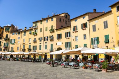 Lucca, İtalya - Eylül 2018. Turistler Lucca 'daki ünlü Piazza dell' Anfiteatro meydanını ziyaret ettiler.