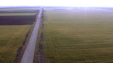 Gri yağmurlu bir günde iki büyük tarla arasında bir kameralı drone ile uçmak.