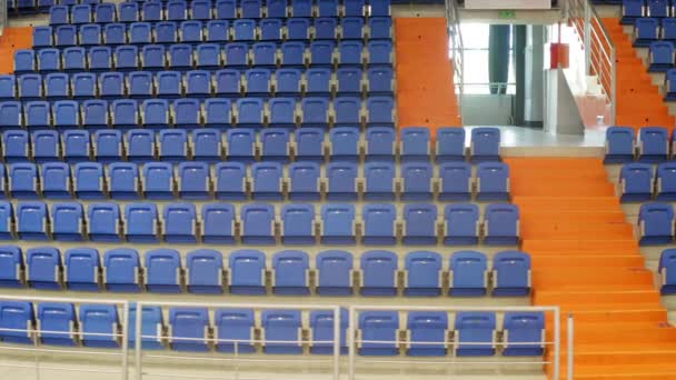 无人机在一个空荡荡的体育馆内鸣枪 空的蓝色座位 — 图库视频影像