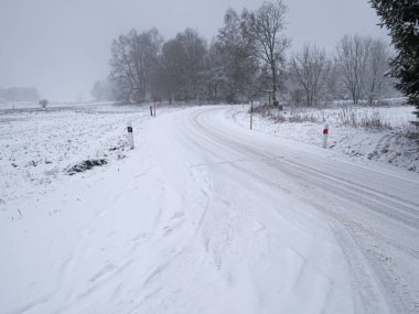Şiddetli kar yağışı sırasında tehlikeli dağ asfaltı yolu, kötü hava, sis, karla kaplı ağaçlar. Jeseniky Dağları, Çek Cumhuriyeti.