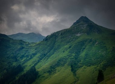 Bir yaz günü Saalbach Hinterglemm kayak merkezi yakınlarındaki dağlarda yeşil çayırlar, dağlar, bulutlar. Alpler, Avusturya.
