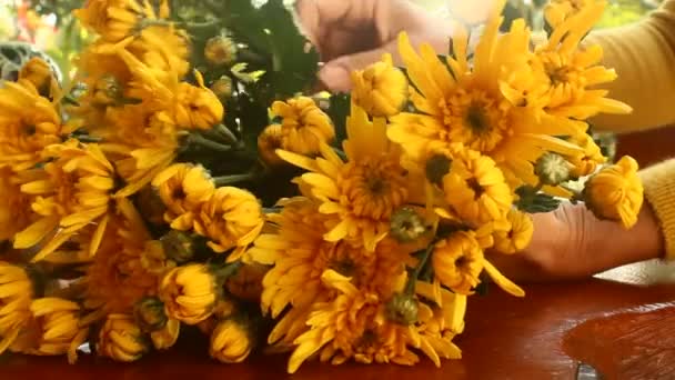 Closeup των χεριών της νεαρής γυναίκας Ανθοπωλείο δημιουργώντας μπουκέτο λουλουδιών στο τραπέζι — Αρχείο Βίντεο
