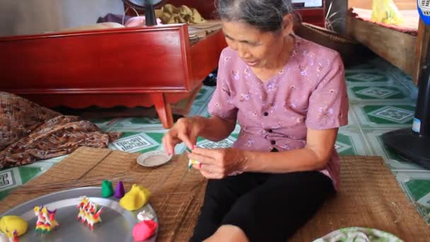 Old woman squeeze toys for kids with colored rice powder — Stock Video