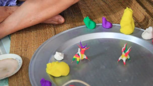 Viejo hombre exprimir juguetes para niños con color arroz en polvo — Vídeo de stock