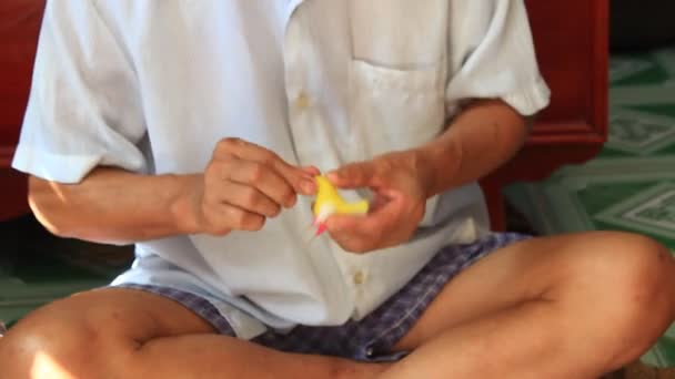 Stary człowiek wycisnąć zabawek dla dzieci z ryż kolorowy proszek — Wideo stockowe