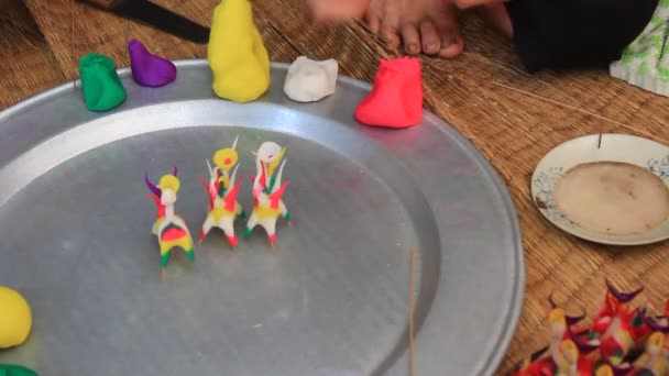 Alte Frau quetscht Spielzeug für Kinder mit farbigem Reispulver — Stockvideo