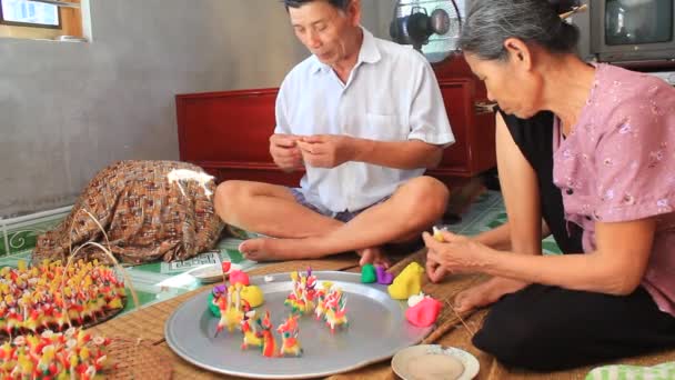 Una famiglia spremere i giocattoli per i bambini con polvere di riso colorata — Stockvideo