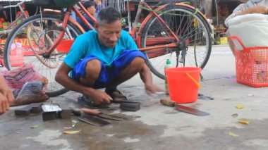 Demirci müşteri içinde belgili tanımlık çarşı için bir bıçak keskinleştirir