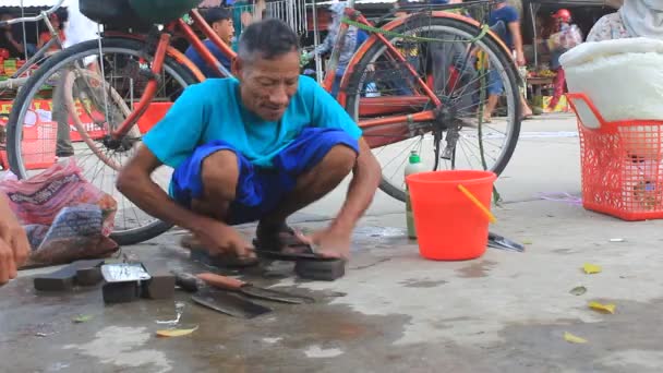 Un fabbro affila un coltello per il cliente sul mercato — Video Stock