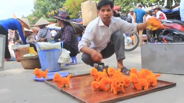 Чоловік продає бавовна іграшка собака на ринку — стокове відео