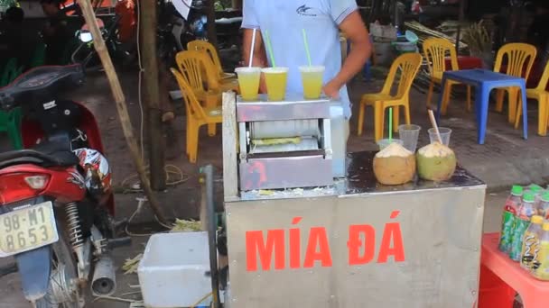 Hombre vendiendo jugo de caña de azúcar prensado en el mercado — Vídeos de Stock