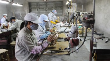HAI DUONG, VIETNAM, August, 3: workers castigate bronze casting  clipart