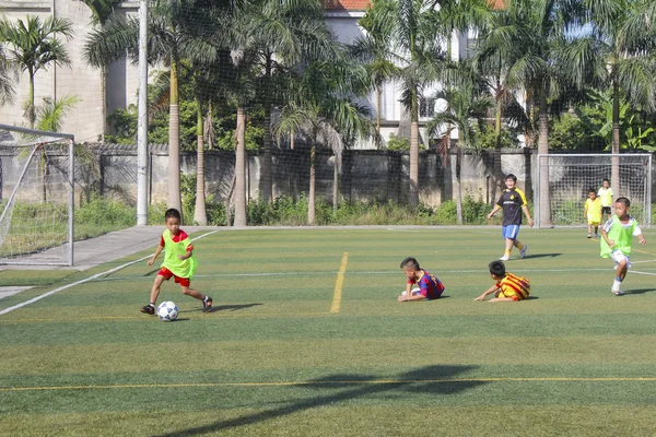 HAI DUONG, VIETNAM, JULIO, 30: niños jugando al fútbol en la cancha Imagen de archivo