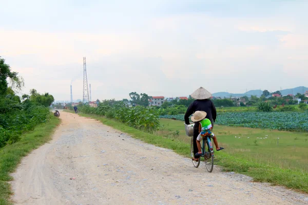 Mulher asiática montando uma bicicleta na estrada — Fotografia de Stock