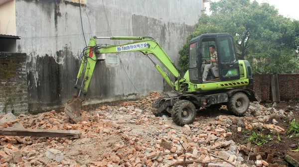 Trabajadores control pesado excavadora construcción casa —  Fotos de Stock