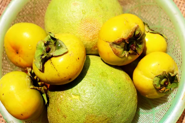 Los caquis y el pomelo en la canasta — Foto de Stock