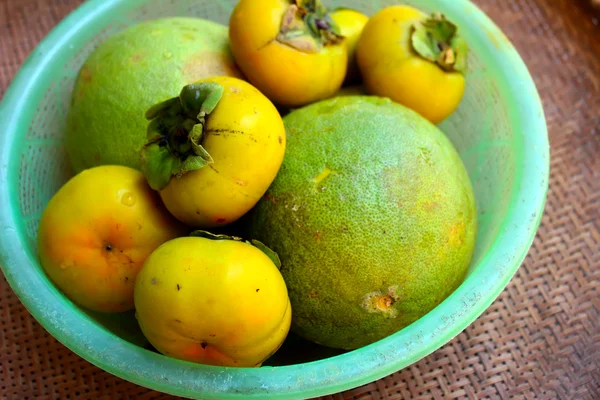 The persimmons and grapefruit in the basket — Stock Photo, Image