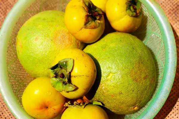 The persimmons and grapefruit in the basket — Stock Photo, Image