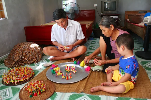 Una familia exprimir juguetes para niños con polvo de arroz de color — Foto de Stock