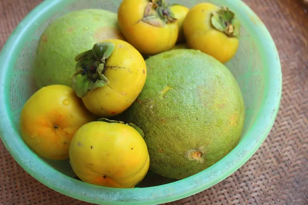 Os caqui e a toranja no cesto — Fotografia de Stock