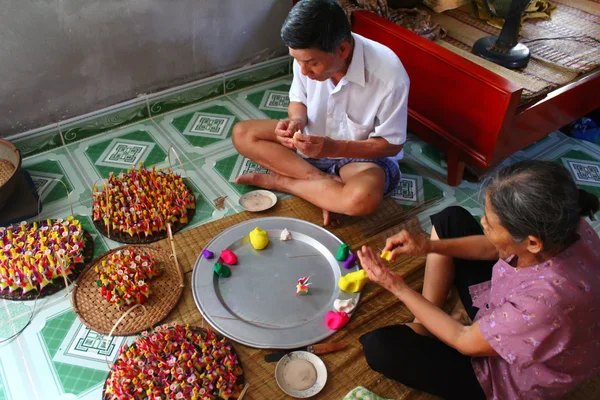 Eine Familie quetscht Spielzeug für Kinder mit farbigem Reispulver — Stockfoto