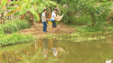 Asian man fishing with net in the pond 