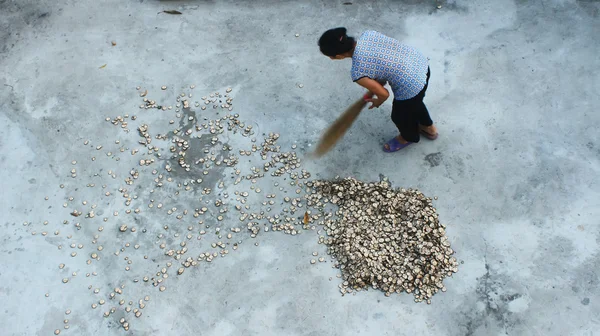 Mujer con una escoba barriendo el patio —  Fotos de Stock