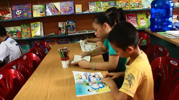 Niños leyendo en la biblioteca — Vídeo de stock