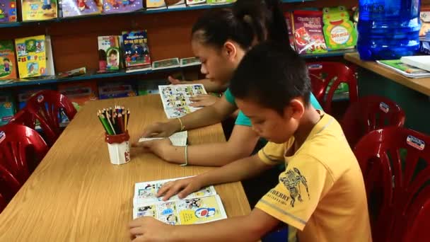 Niños leyendo en la biblioteca — Vídeo de stock