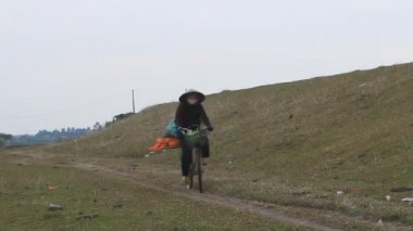 Haiduong, Vietnam, 9 Nisan 2015, kadın sahada Bisiklete binme