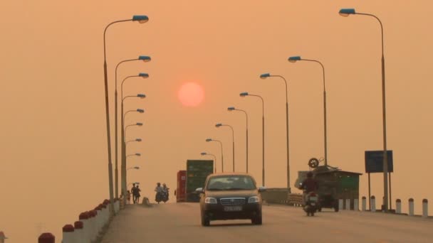 Haiduong，越南，2015 年 4 月 21 日，身份不明的车手骑摩托车在繁忙的马路上在日落时分 — 图库视频影像