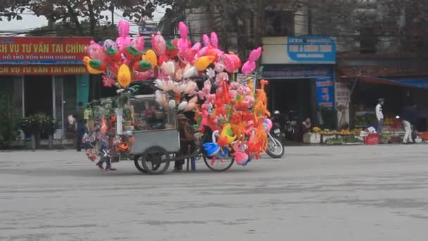 Haiduong, Vietnam, únor, 15, 2015: Neznámý muž prodávající balónky na ulici — Stock video