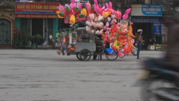 Haiduong, Vietnam, únor, 15, 2015: Neznámý muž prodávající balónky na ulici — Stock video