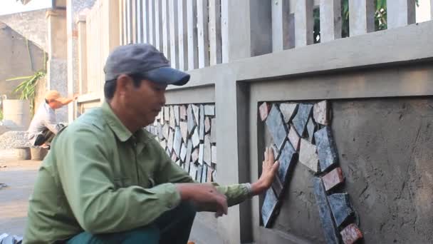 HAI DUONG, VIETNAM, 12 OCTOBRE : Un travailleur installe une surface murale en pierre avec du ciment le 12 octobre 2014 à Hai Duong, Vietnam — Video