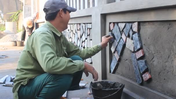 HAI DUONG, VIETNAM, OCTUBRE, 12: trabajador instala la superficie de la pared de piedra con cemento el 12 de octubre de 2014 en Hai Duong, Vietnam — Vídeos de Stock