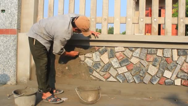 HAI DUONG, VIETNAM, OCTUBRE, 12: trabajador instala la superficie de la pared de piedra con cemento el 12 de octubre de 2014 en Hai Duong, Vietnam — Vídeos de Stock